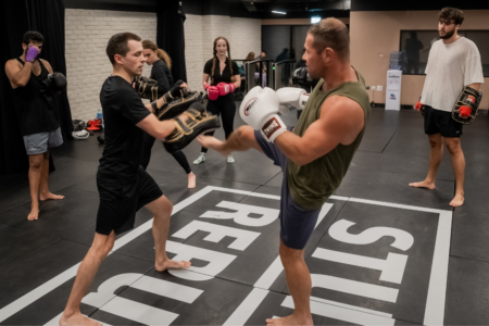 Martial Arts Trainer teaching kickboxing to a man